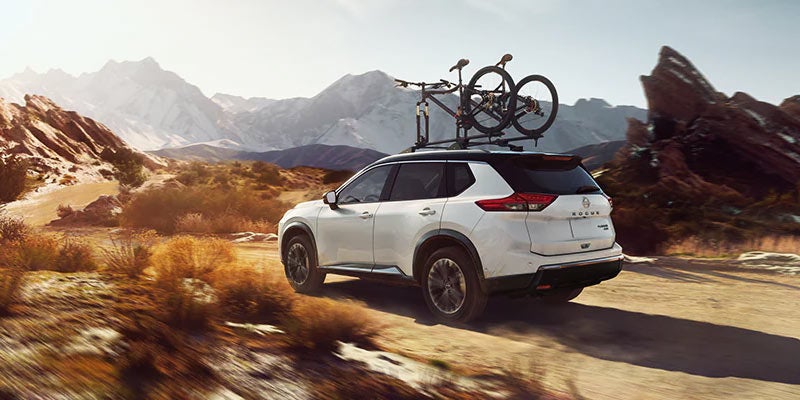 A 2024 Nissan Rogue driving with a roof rack of bikes going to a trail near Pompano Beach, FL