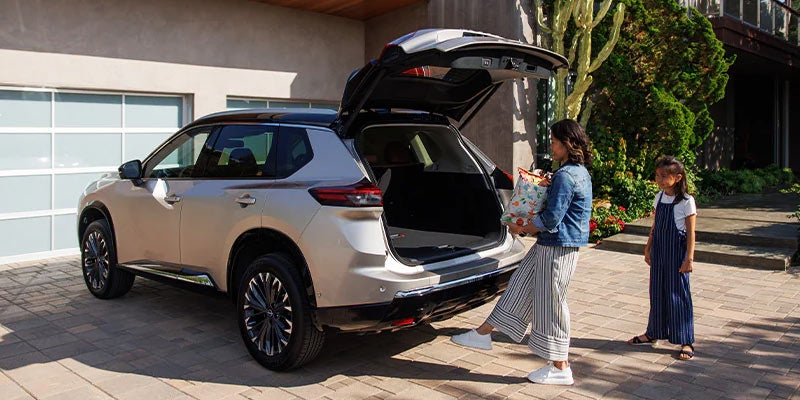 A family using the hands-free lift gate option on the 2024 Nissan Rogue in Pompano Beach, FL