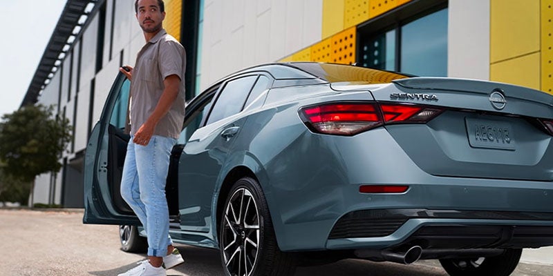 A driver getting out of their 2025 Nissan Sentra in Pompano Beach, FL
